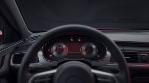 Driver's-eye view of a darkened car interior past the steering wheel, showing several red and amber warning lamps lit across the instrument cluster