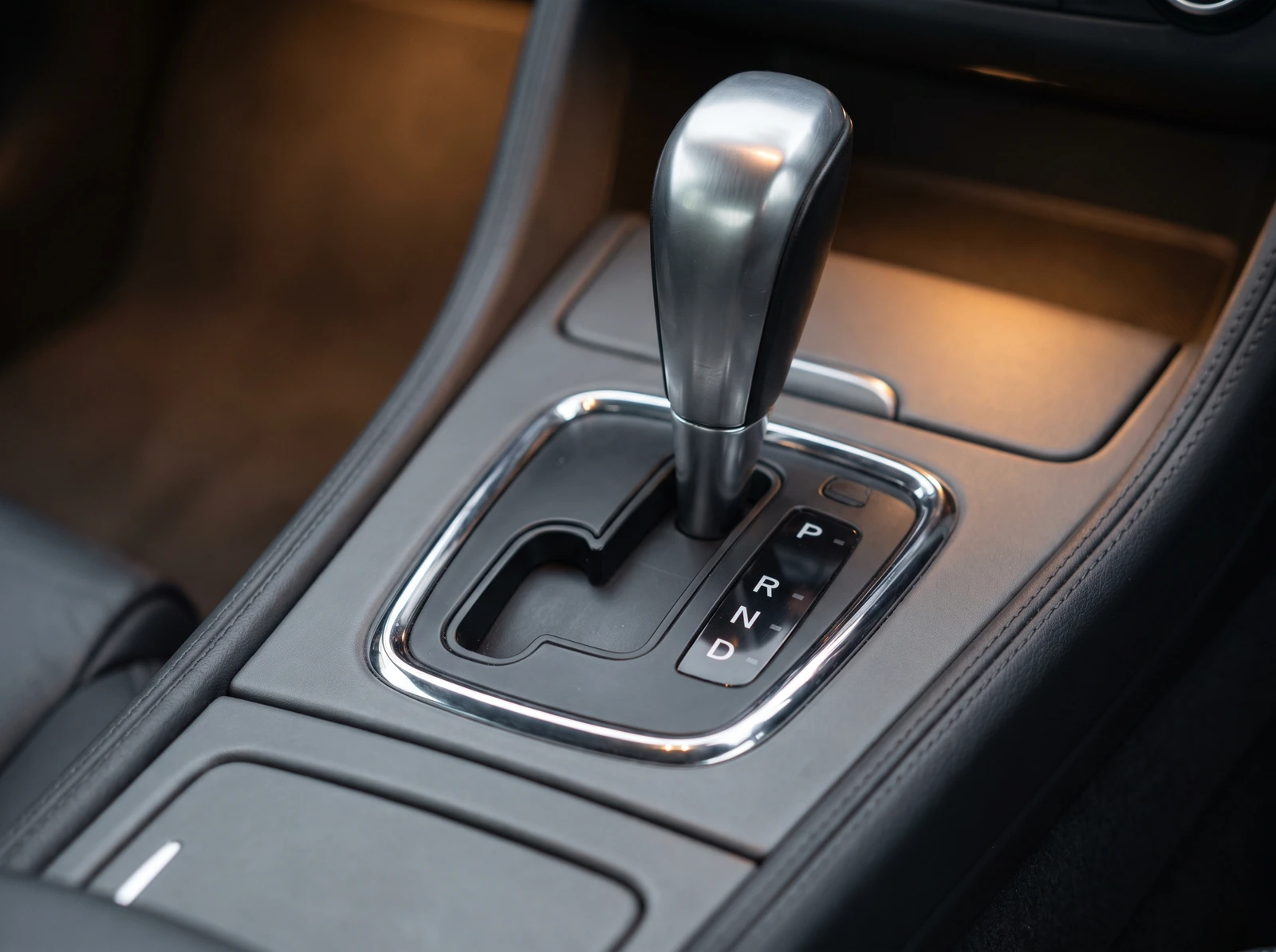Close-up of a car automatic gearbox selector lever and P R N D gate, the range sensor that P0705 reports on